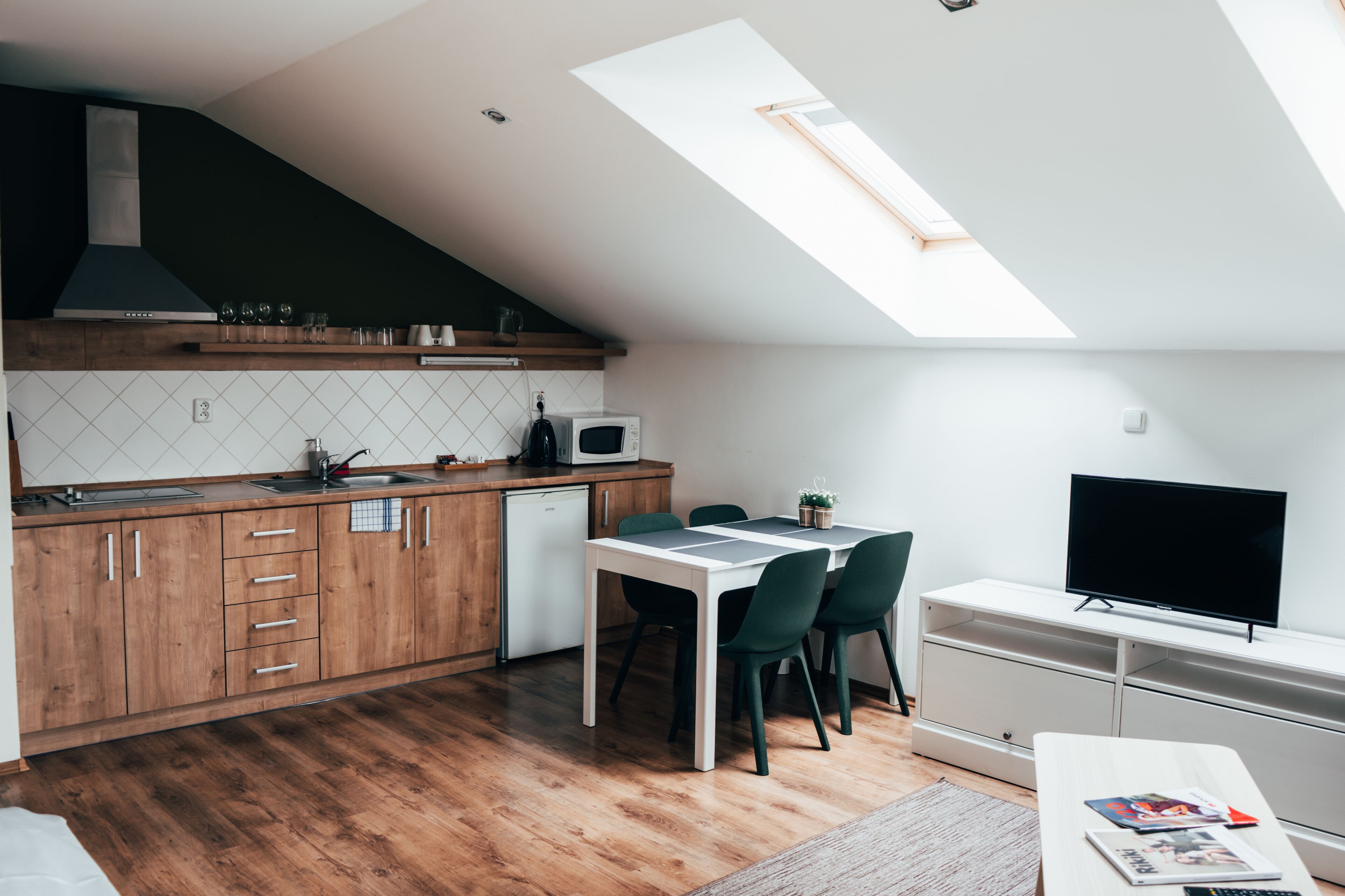 Eine moderne Küche mit Holzausstattung, einer Mikrowelle und einem Essbereich mit Tisch und Stühlen.