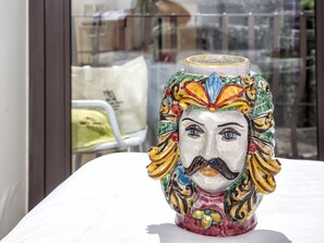 A colorful ceramic vase with a floral design on a table. - Porta del Tocco Design Rooms (Taormina)