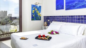 A hotel room with a bed, breakfast tray, and artwork on the walls. - Porta del Tocco Design Rooms (Taormina)