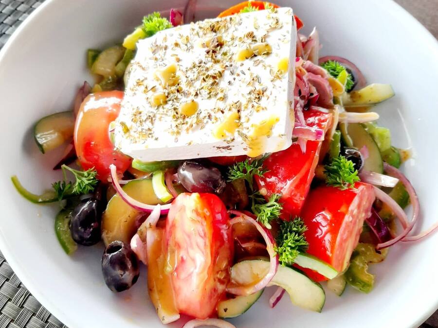 Ensalada con queso feta, pepinos, tomates, aceitunas y cebollas rojas.