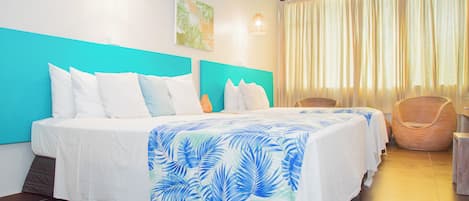 A hotel room with a bed, two bedside tables, a chair, and a window with curtains.