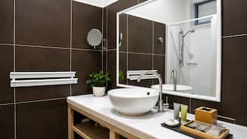 Un baño moderno con un lavamanos tipo recipiente, un espejo y una ducha.