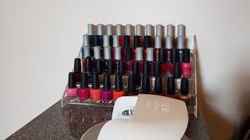 Un rangement pour vernis à ongles contenant plusieurs flacons, posé sur un comptoir.