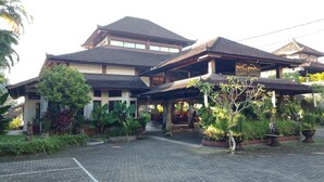 A traditional building with a sign reading "puri padi" and a covered entrance area. - Puri Padi Hotel (Ubud)