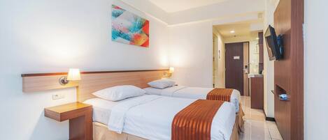 Een hotelkamer met twee bedden, een houten hoofdbord, een nachtkastje met een lamp, een tv aan de muur en een kleurrijk abstract schilderij.