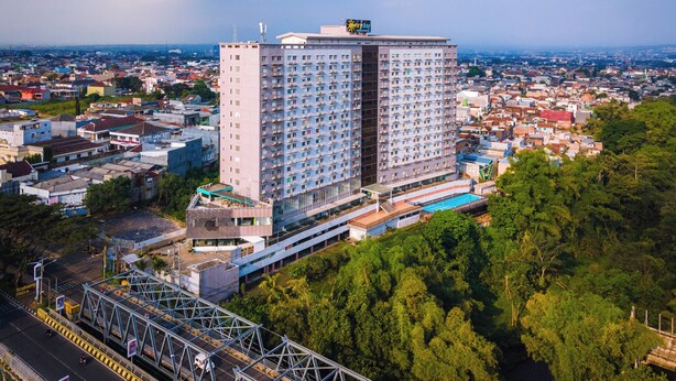 Un hotel grattacielo con numerosi piani, una piscina e vista sulla città circostante.