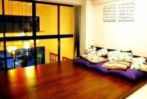 Ein Essbereich mit Holztisch und einer Couch mit gemusterten Kissen.