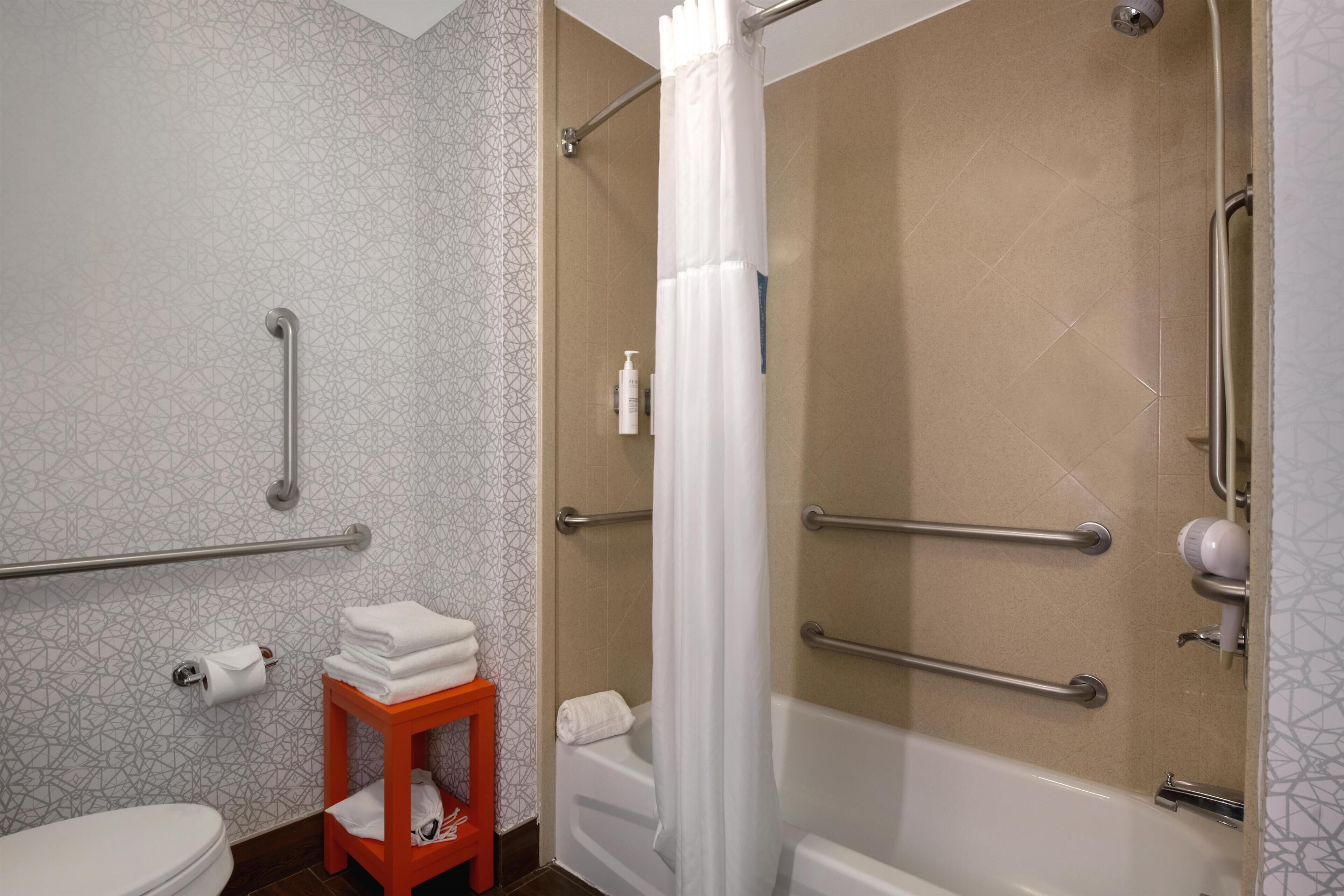 A bathroom with a toilet, a shower with a glass door, and a sink with a towel rack.