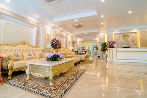 A luxurious lobby with a plush sofa, elegant coffee table, and a reception desk.