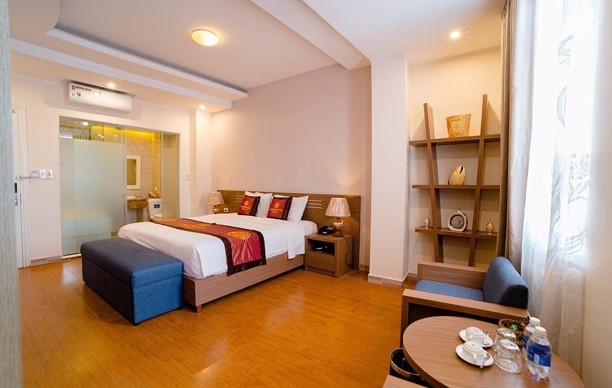 Habitación de hotel con cama, mesita de noche y una pequeña zona de estar con mesa.