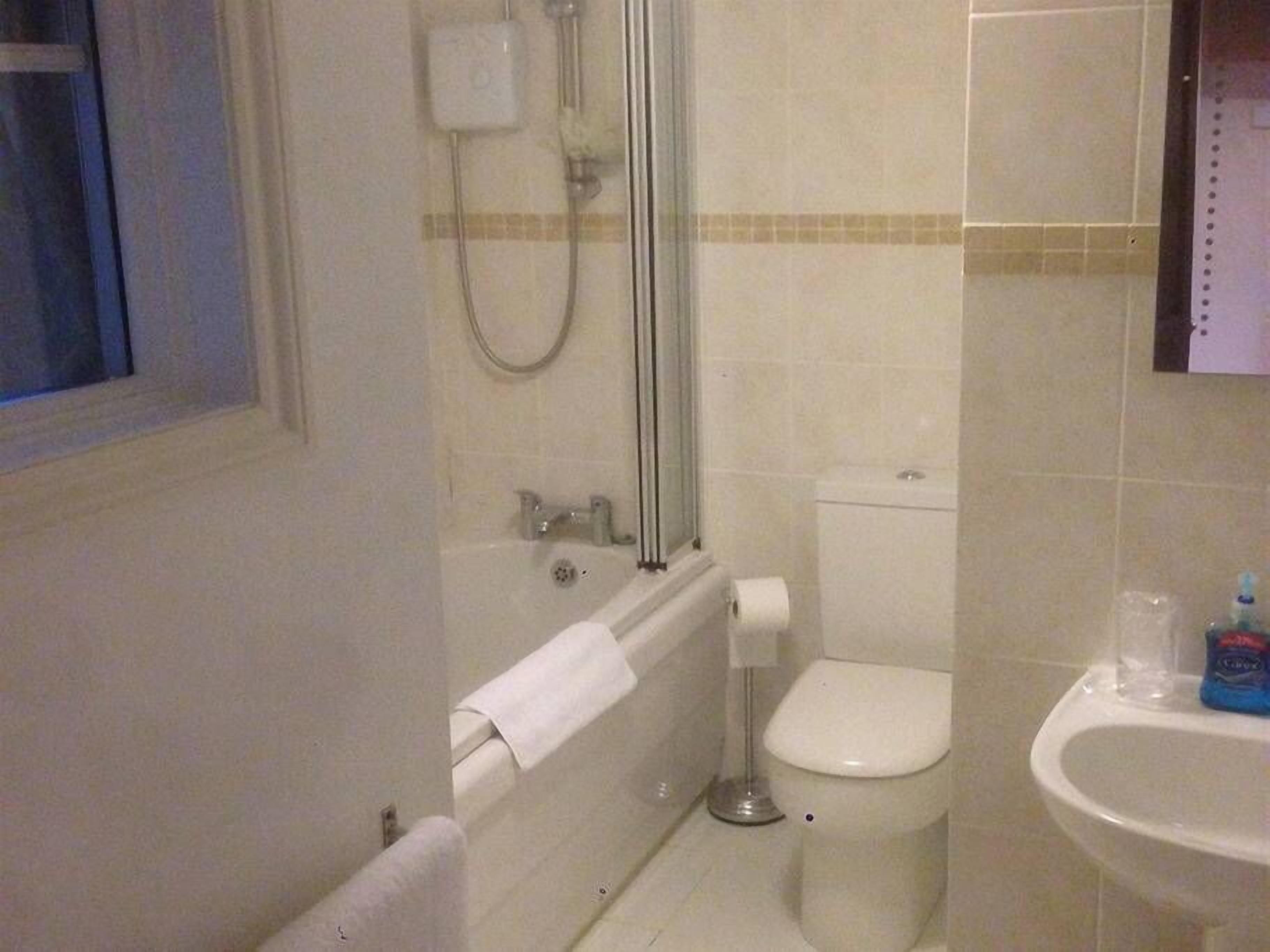 Ett badrum med badkar, toalett och handfat.