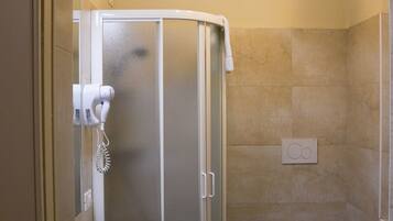 A bathroom with a sink, toilet, and glass shower enclosure.