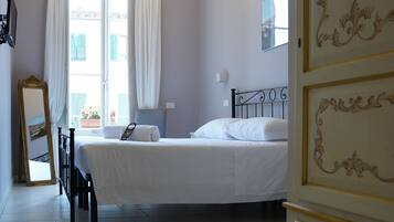 Une chambre à coucher avec un lit, un lustre, une commode et un miroir.