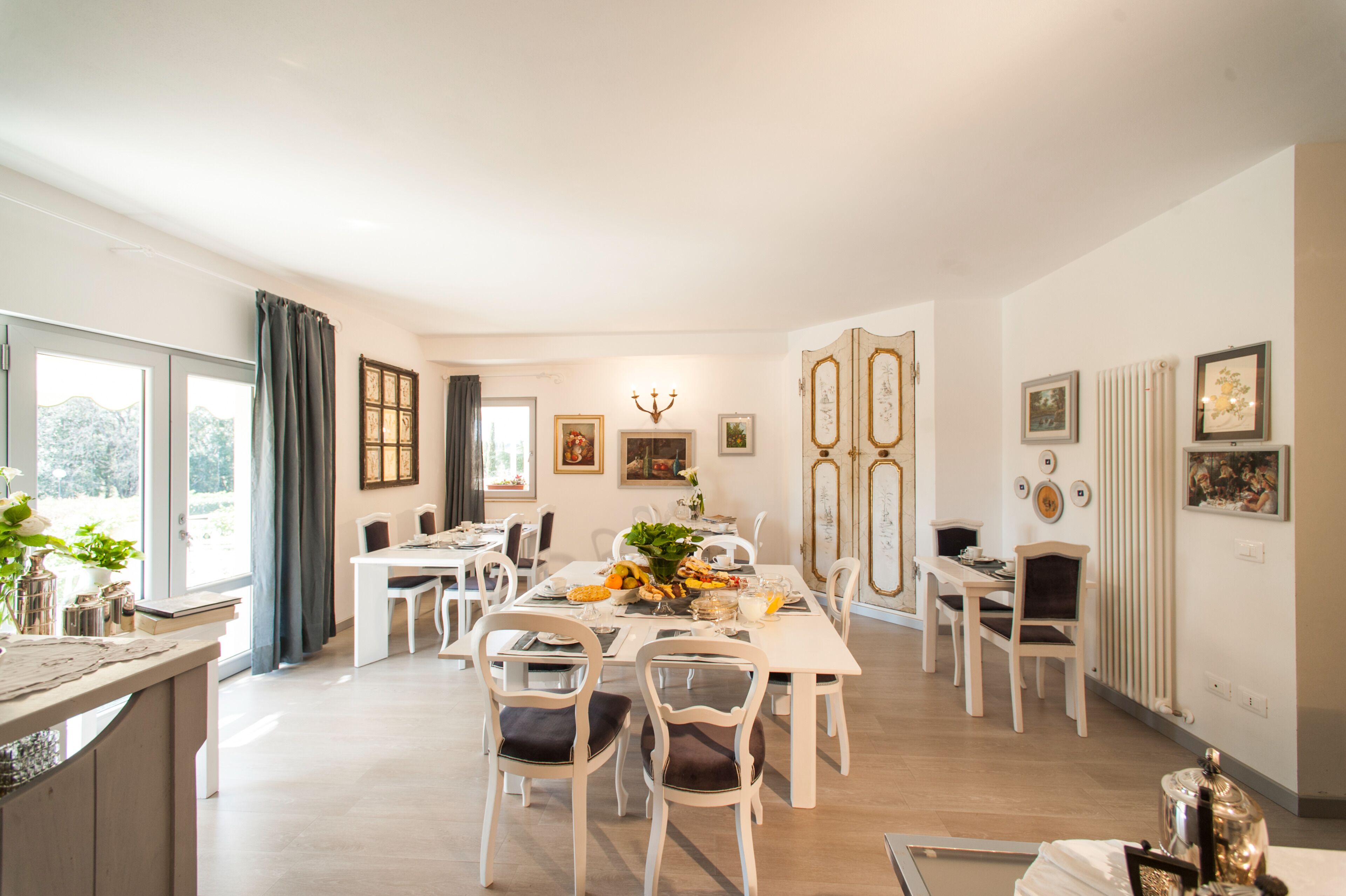 A dining area with a large table, chairs, and a chandelier.