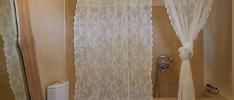 A bathroom with a shower, toilet, and a sink.