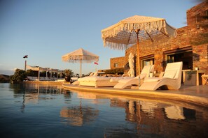 Alberca al aire libre, sombrillas en la alberca y camastros 