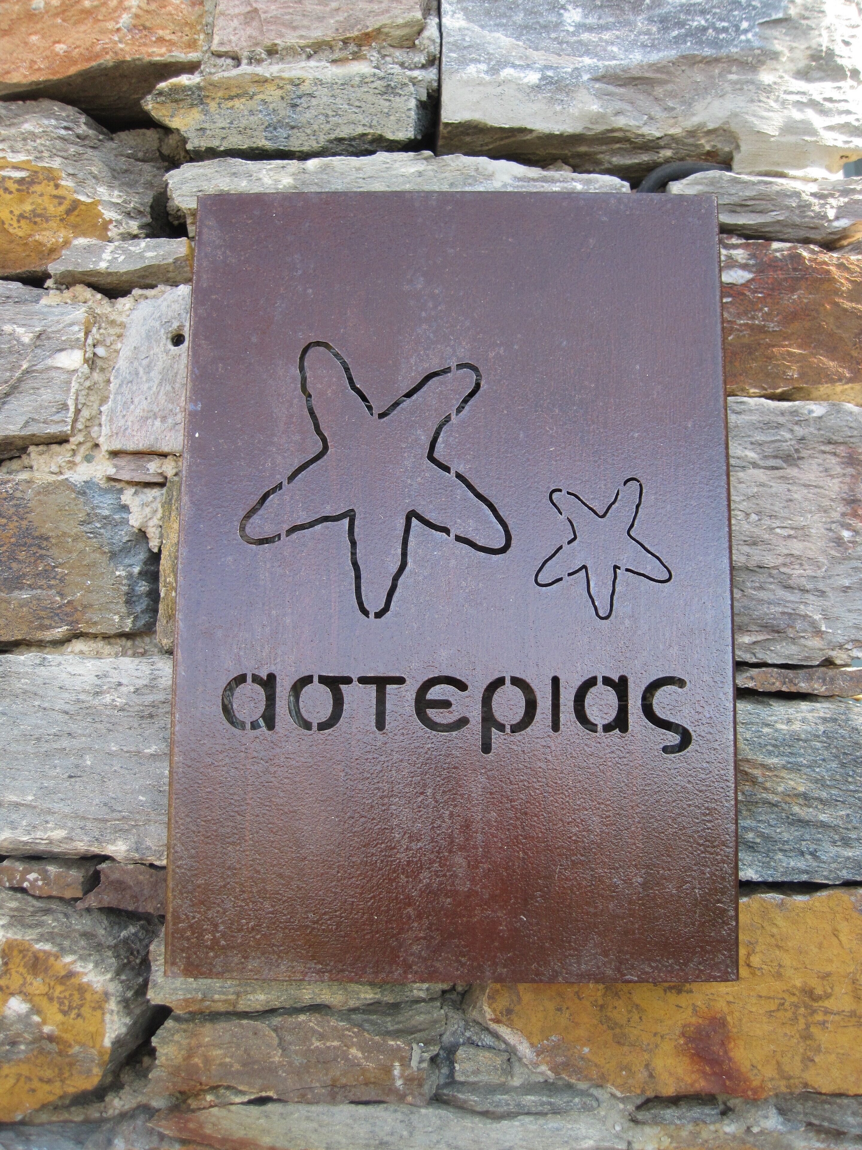 Un cartel con una estrella y la palabra 'AOTEPIAS' en una pared de piedra.