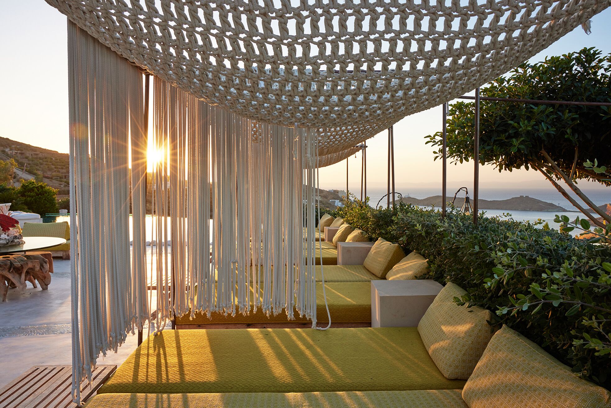 Une terrasse en bord de mer, dotée d’un auvent en osier, de sièges confortables et offrant une vue sur l’océan.