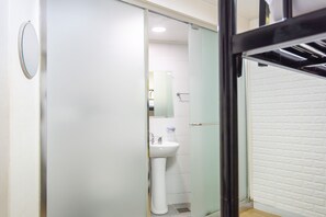 Habitación triple | Baño | Ducha, artículos de higiene personal gratuitos y secador de pelo