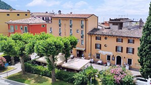 A hotel with a terrace, outdoor seating, and a view of the sea. - HOTEL DEPENDANCE SILVESTRO (Garda)