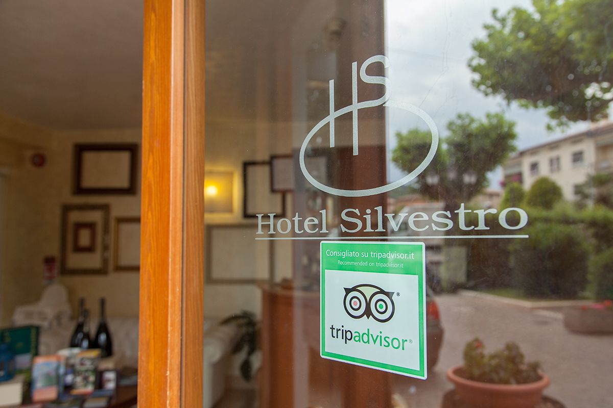 A hotel window with the name "Hotel Silvestro" and a TripAdvisor sticker.