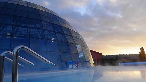 A modern building with a curved glass facade and a reflective pool in front. - HOTEL DEPENDANCE SILVESTRO (Garda)