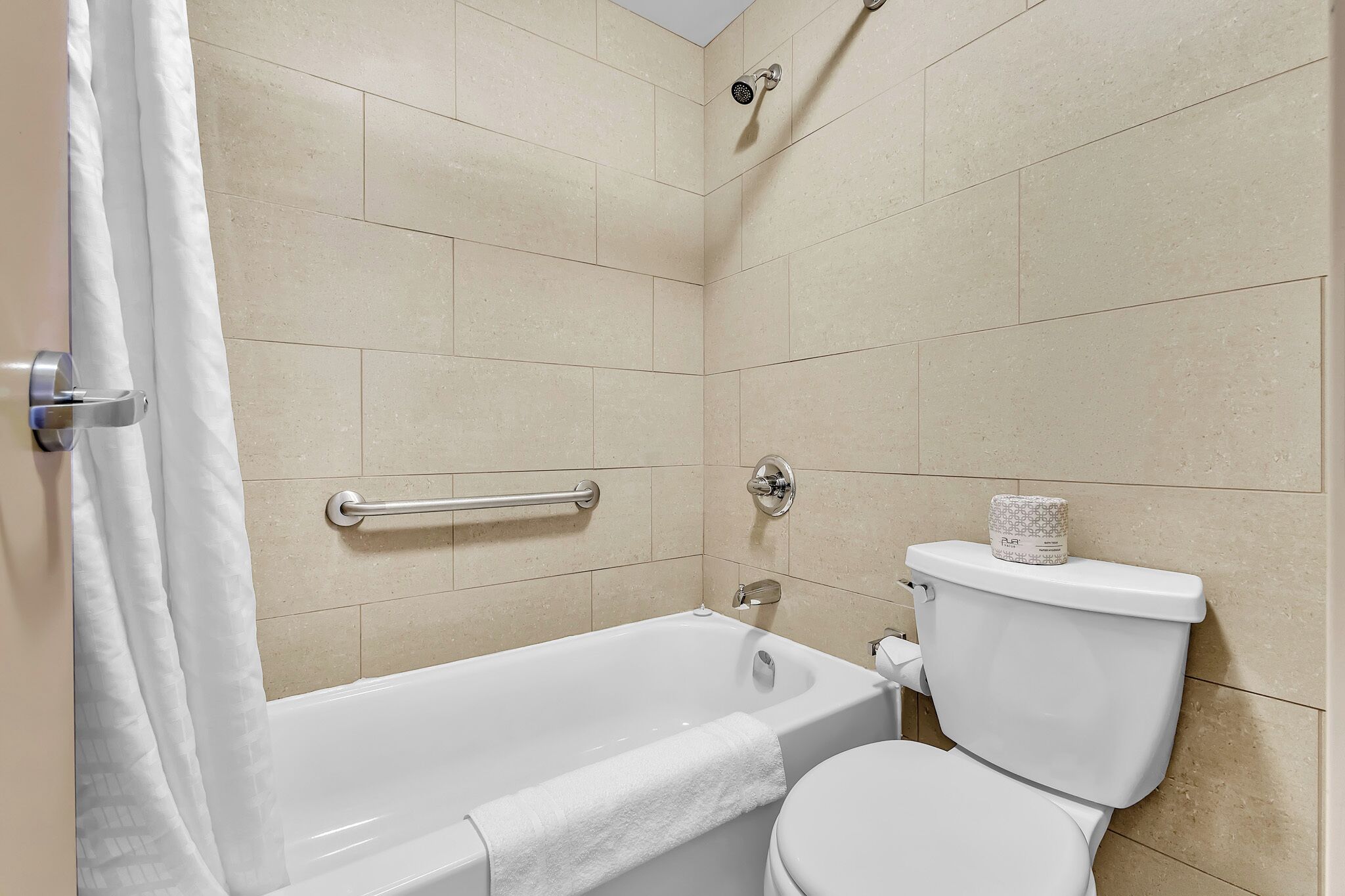 A bathroom with a bathtub, toilet, and shower.
