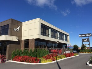 A modern motel with a prominent sign reading "Motel Adam" and a logo on the building. - Motel Adam (Gatineau)