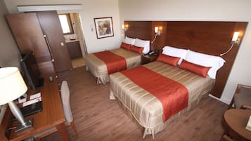 A hotel room with two beds, a desk, and a chair.
