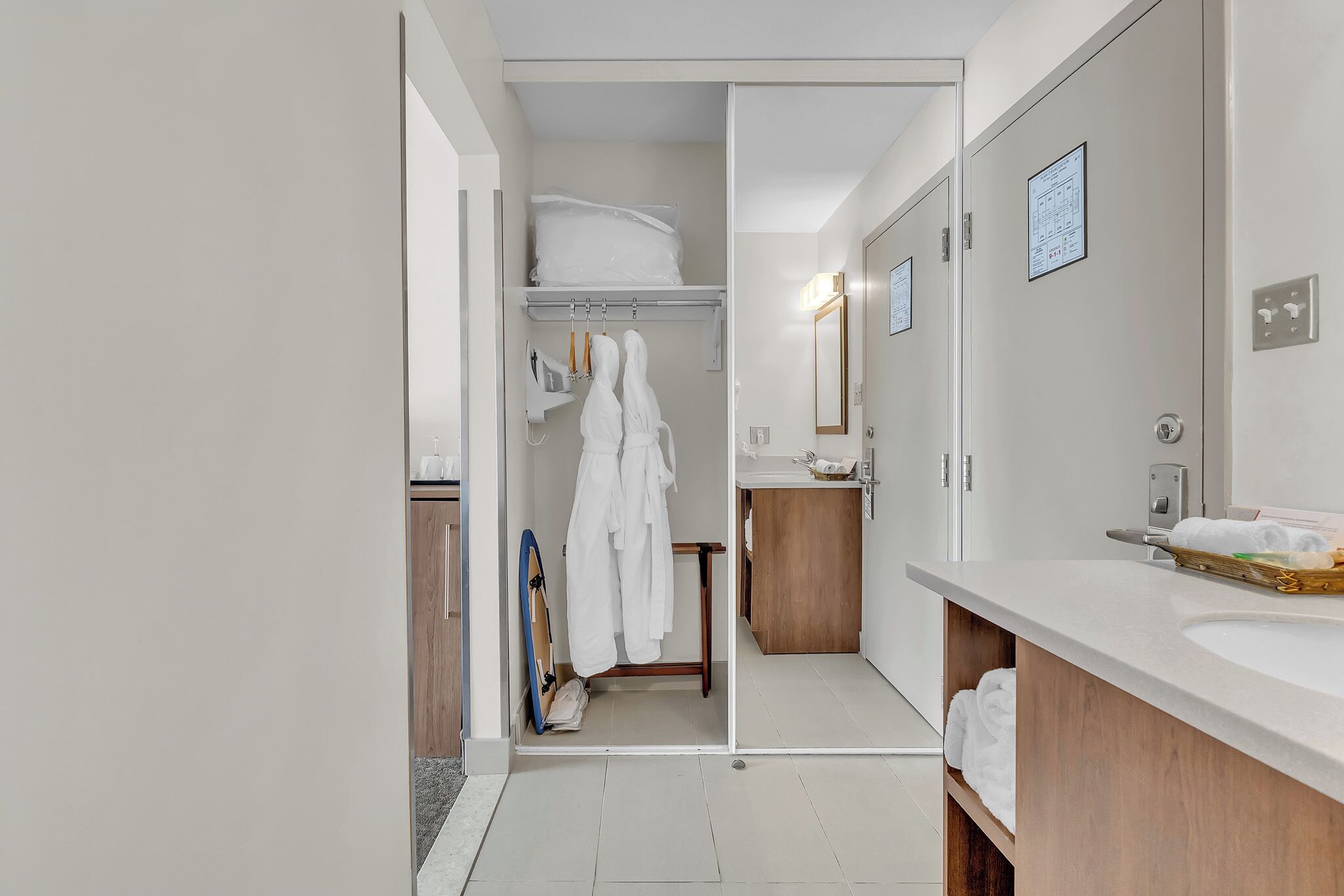 A modern bathroom with a large mirror, a wooden vanity, and a shower area.