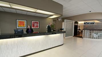 A reception area with a curved counter, framed artwork on the wall, and a sign with a logo.