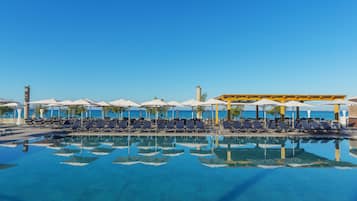 Piscine couverte, piscine extérieure, parasols de plage, chaises longues