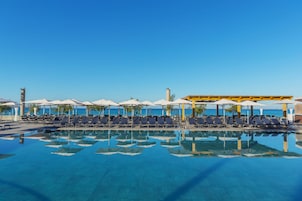 Una piscina cubierta, una piscina al aire libre, sombrillas, tumbonas