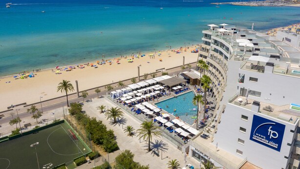 Un hôtel doté d’une piscine, d’une plage et offrant une vue sur l’océan.