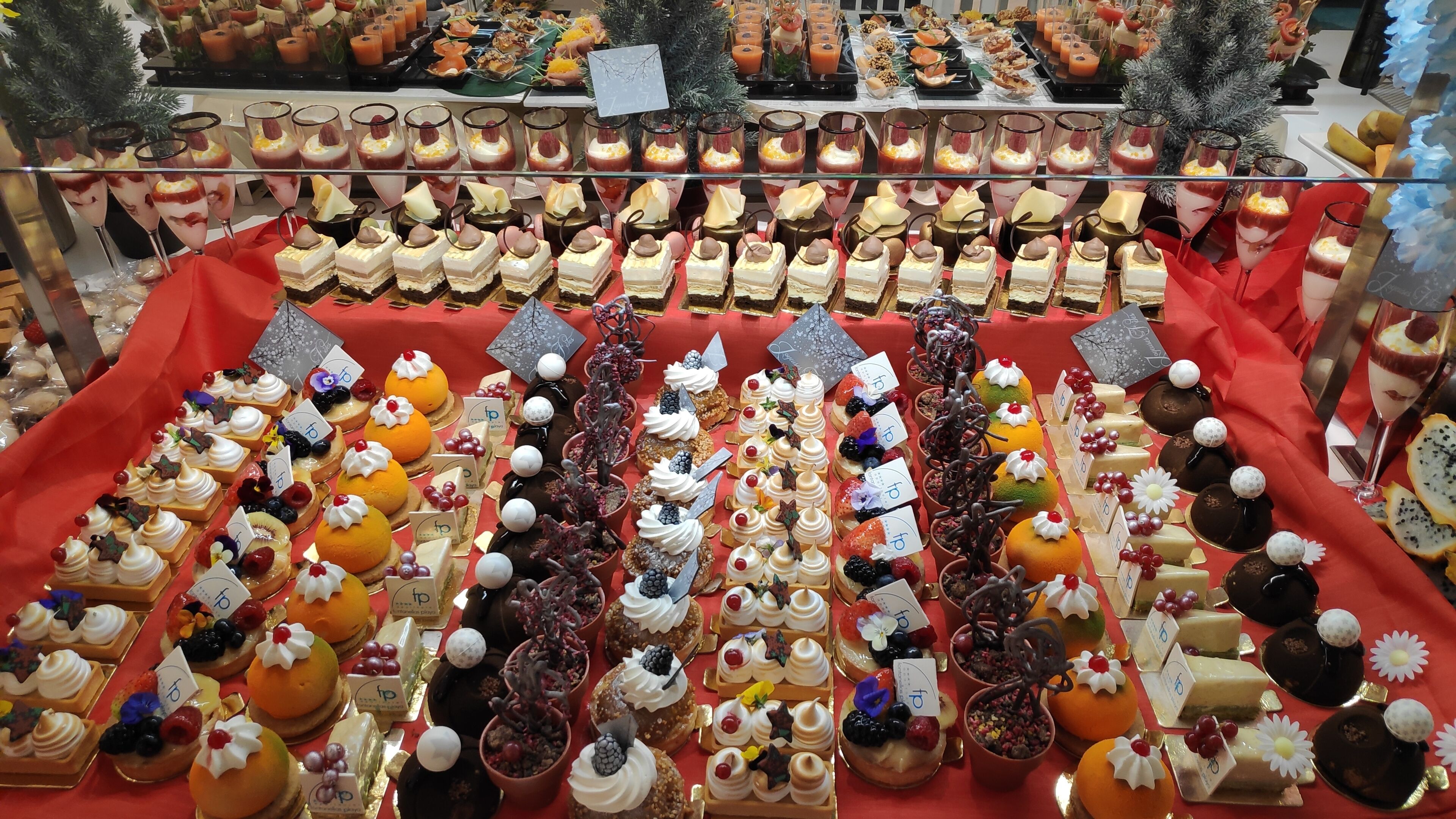 A variety of desserts and beverages displayed on tables, with some items labeled with numbers.
