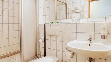 A bathroom with a toilet, sink, and shower.
