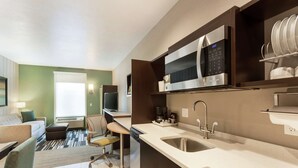 A modern kitchen with a microwave, sink, and a dining area with a sofa and chair. - Home2 Suites by Hilton Salt Lake City-Murray, UT (Murray)