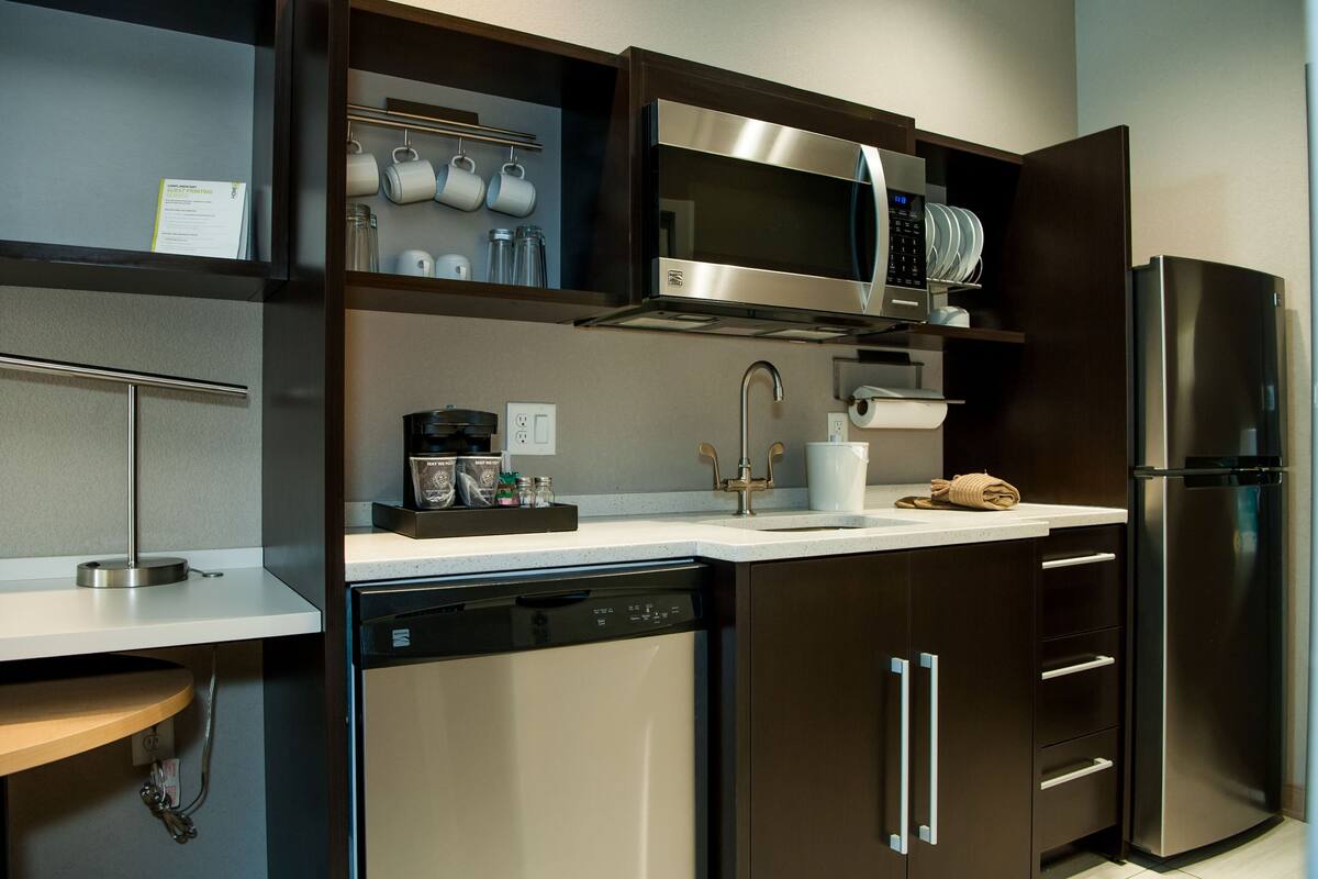 A modern kitchen with a dishwasher, stainless steel appliances, and a built-in oven.