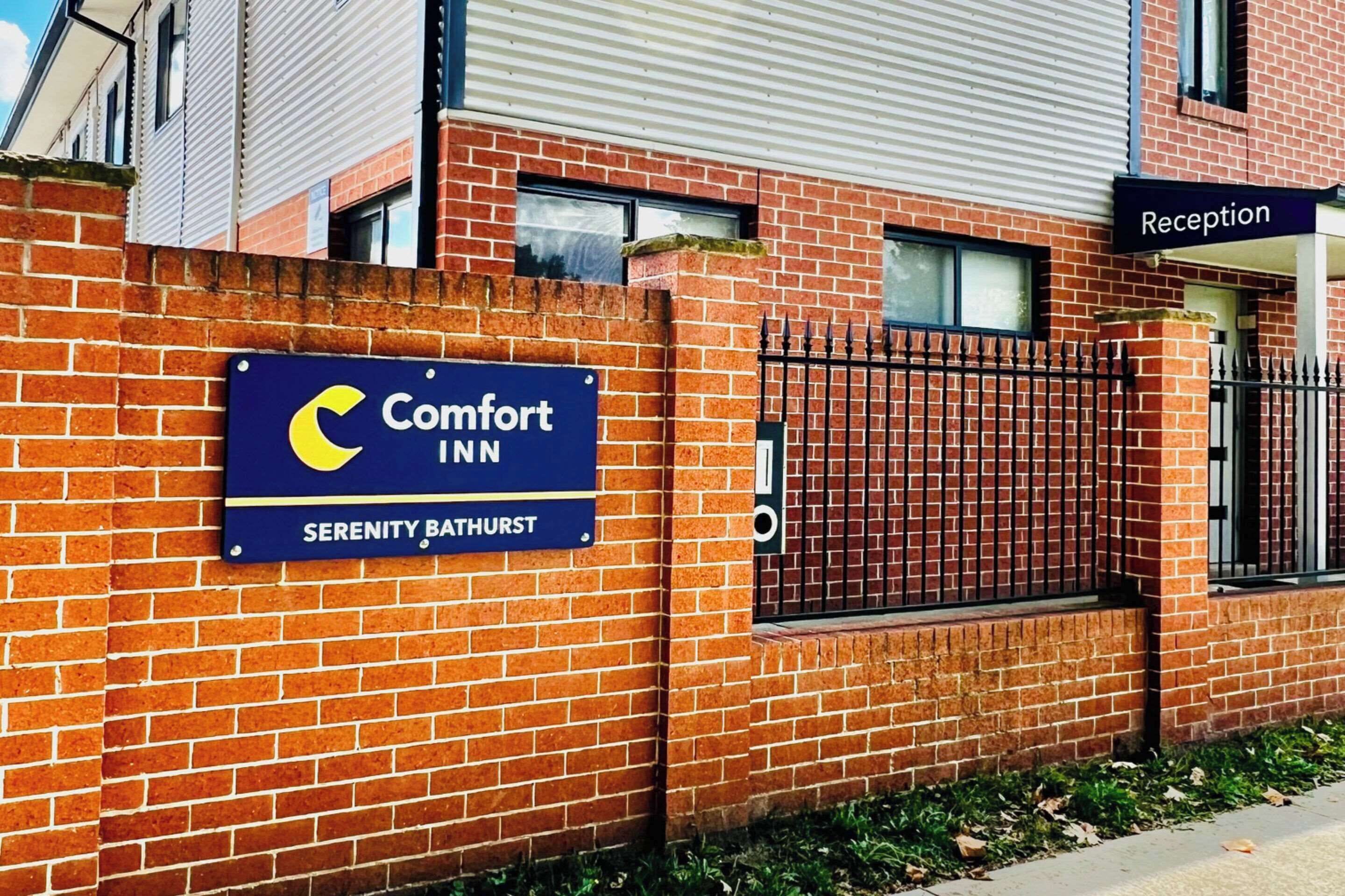 Ein Backsteinhaus mit einem Schild für Comfort Inn Serenity Bathurst.