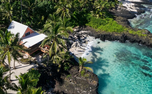 A coastal property with a house, surrounded by lush greenery and clear turquoise waters. - Sa'Moana Beach Bungalows (Salamumu)