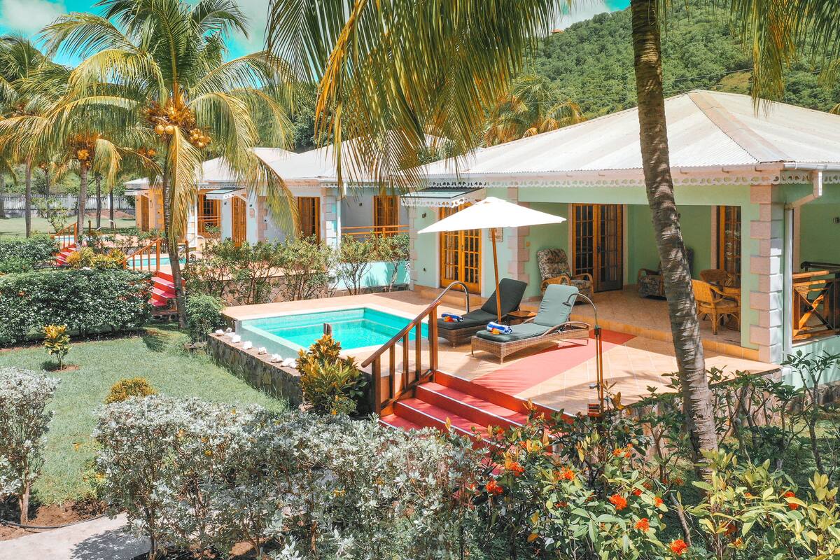 A resort with a swimming pool, lounge chairs, and a covered patio area.