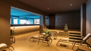 Un área interior moderna para relajarse con sillones, un mostrador de recepción y una escalera.