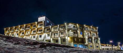A multi-story hotel with balconies and a sign indicating it is a hotel and restaurant.