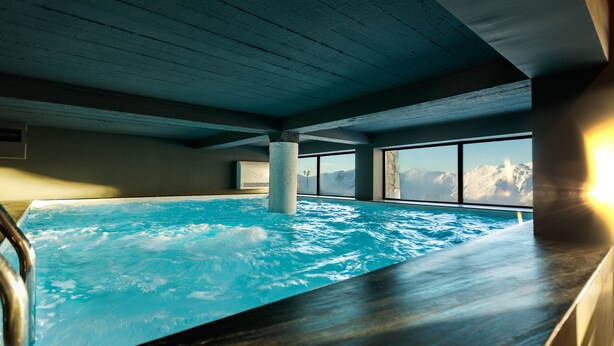 Una amplia piscina interior con vistas despejadas a montañas a través de las ventanas.