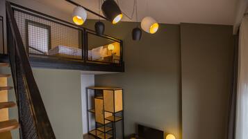Un dormitorio estilo loft moderno con entrepiso, un armario de madera, un televisor y una escalera.