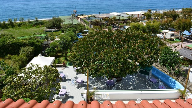 A rooftop pool area with outdoor seating and a view of the ocean. - Hotel Maronti (Barano d'Ischia)