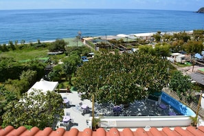 A rooftop pool area with outdoor seating and a view of the ocean. - Hotel Maronti (Barano d'Ischia)