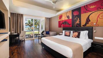 A hotel room with a bed, a desk, a chair, a television, and a view of a pool.