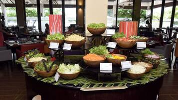A buffet with various salads and vegetables displayed in wooden bowls.