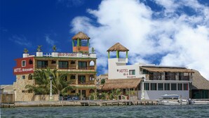 Un hotel con techo de paja, piscina y vistas al mar.